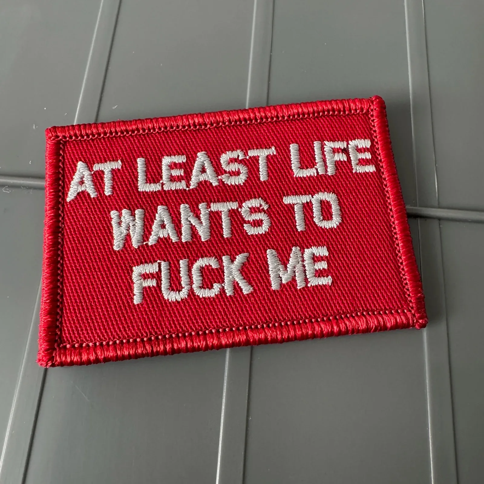 As Seen on Socials - At Least Life Wants To Fuck Me - Red w/Silver